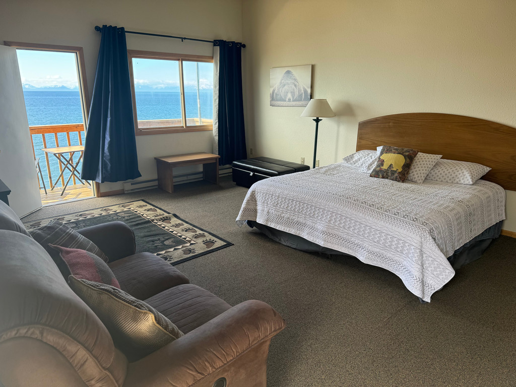 Bear Suite king bed with ocean view through balcony windows