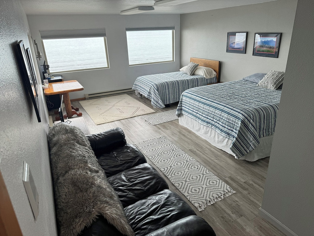 Family room with two double beds, ocean view, and sitting area